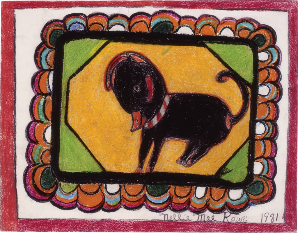 black animal with an orange mouth sits on a colorful rug with scalloped detailing. 