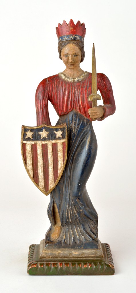 American polychrome carved wooden sculpture in the form of Lady Liberty with crown, shield and sword on carved wooden base, exhibited at the American Folk Art Museum, NYC