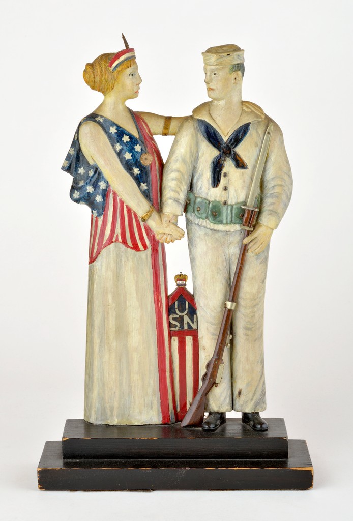 American polychrome carved wooden figural group depicting Miss Liberty holding hands with American Sailor holding rifle, USN inscribed on panel between figures, inscribed on back H.W. Chaloner carver, retains cabinet maker’s punch mark