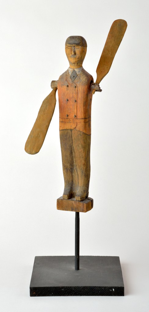 American polychrome carved wooden figural man whirligig with metal buttons on jacket and paddle arms, on wooden base with metal stand