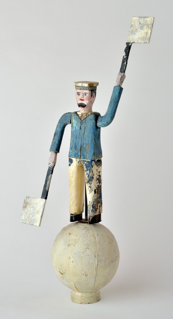 American polychrome carved wooden figural sailor whirligig having Semaphoe flag paddles on white painted ball