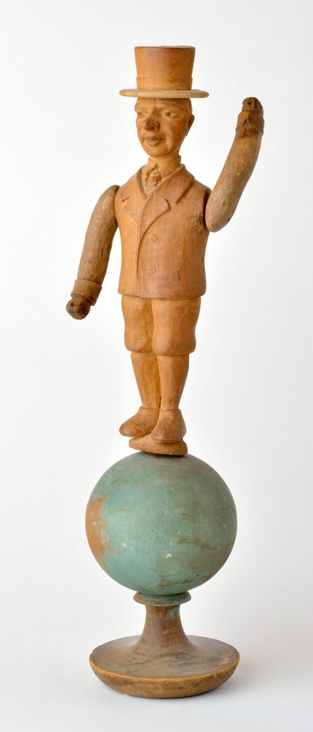 American carved wooden figural man whirligig wearing top hat, tie and jacket, purported to be W.C. Fields on polychrome world globe as stand