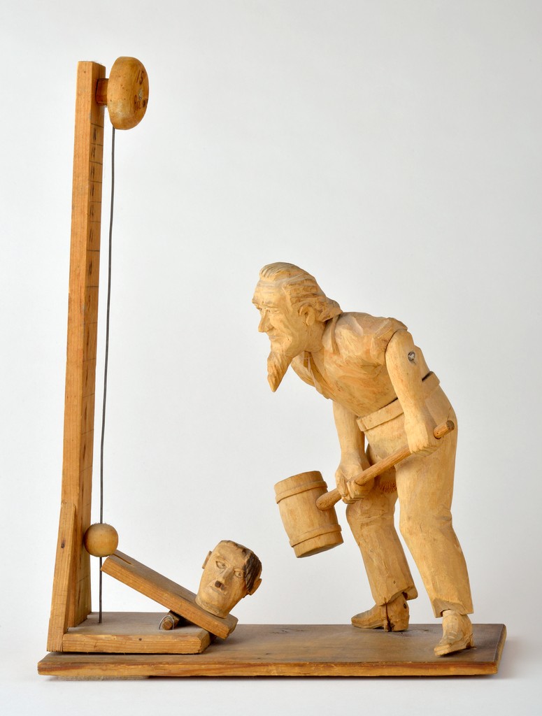 American carved wooden figural group depicting Uncle Sam with sledgehammer about to hit head of Adolf Hitler resting on a wedge as a part of a carnival strength-testing machine