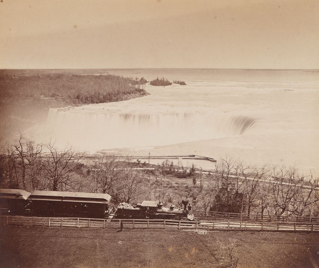 View of Niagara Falls with train in foreground